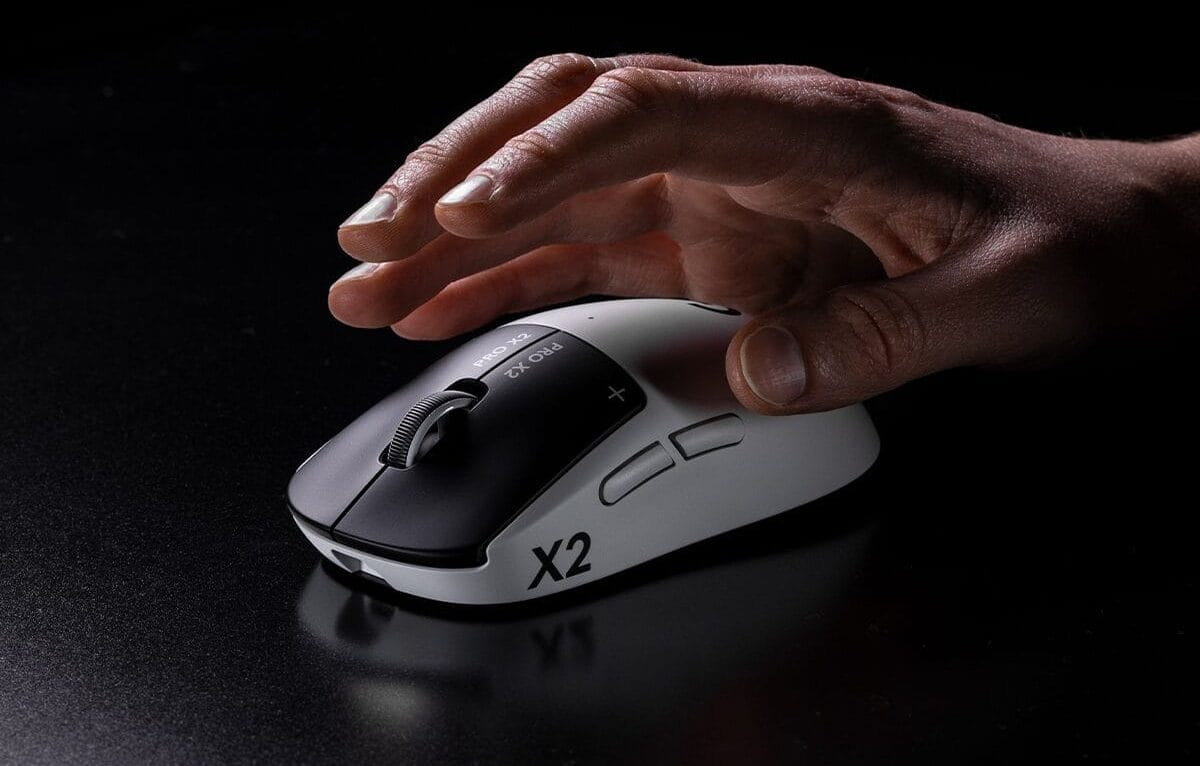 Logitech G PRO X2 SUPERSTRIKE - עכבר גיימינג בצבע לבן עם מקשים שחורים, המוצג בזווית צד תחת יד המשתמש.