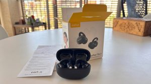 Earfun Clip 2 - אוזניות אלחוטיות פתוחות בתוך מארז טעינה שחור לצד אריזת המוצר המקורית וחוברת הדרכה על שולחן לבן