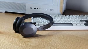 Lenovo ThinkPad 8550 - אוזניות קשת מונחות על שולחן עץ בסביבת עבודה הכוללת מקלדת מכנית ומארז מחשב לבן