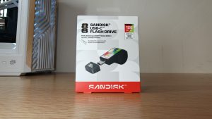 SANDISK Flash Drive FIFA 2026 - אריזת כונן נייד בחיבור USB-C בנפח 128GB מונחת על שולחן עץ