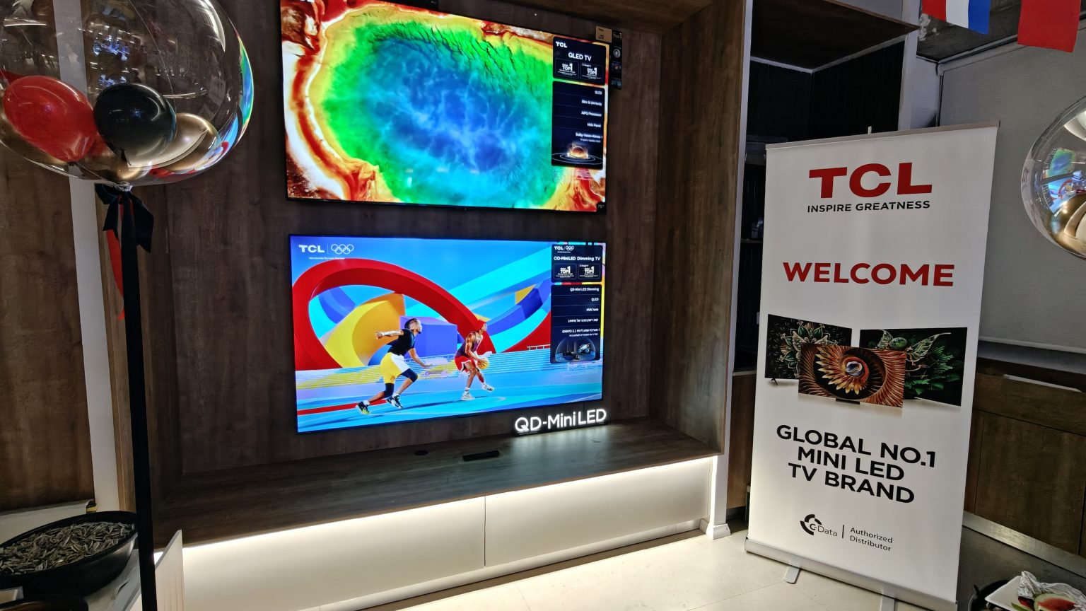 TCL SQD-Mini LED - מסכי טלוויזיה בתצוגה לצד שלט מיתוג רשמי של היבואנית