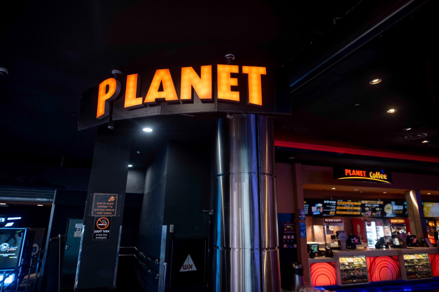 Planet Cinema - שלט הכניסה המואר של מתחם הקולנוע וקפיטריה ברקע