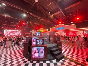 Coca Cola Diner 2026 - מתחם אירוע בעיצוב דיינר רטרו עם רצפת שחמט, מיצג מסכי טלוויזיה וינטג' וקהל