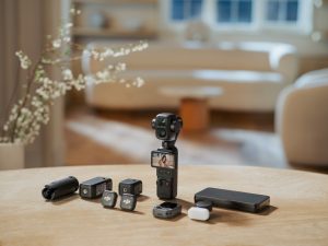 DJI Osmo Pocket 4P - מצלמת גימבל קומפקטית לצד מגוון אביזרים ומיקרופונים אלחוטיים על שולחן עץ