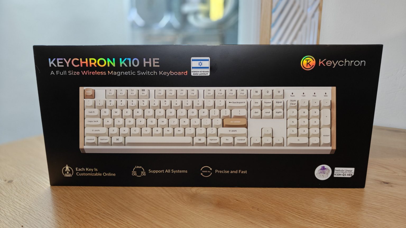 Keychron K10 HE - אריזת המקלדת עם הדפסה בעברית על גבי שולחן עץ