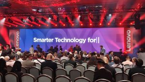 Lenovo IFA 2026 - קהל באולם מול במת אירוע עם מסך ענק של לנובו ותאורה אדומה