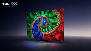 TCL Q7D RGB - מסך טלוויזיה המציג גרפיקת ספירלה צבעונית של אבני חן ירוקות, כחולות ואדומות על רקע כהה